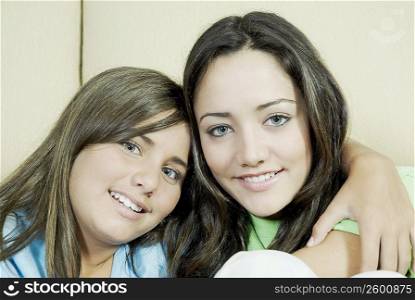 Portrait of a teenage girl sitting with her sister and smiling