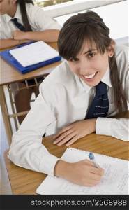 Portrait of a teenage girl smiling in a classroom