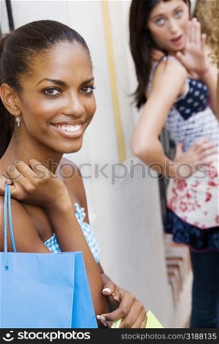 Portrait of a teenage girl smiling with another teenage girl standing beside her