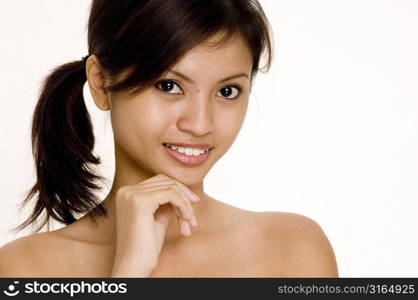 Portrait of a teenage girl smiling with her hand on her chin