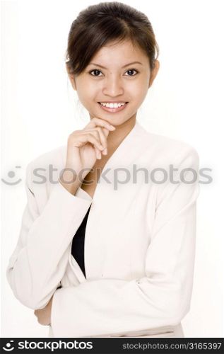 Portrait of a teenage girl smiling with her hand on her chin