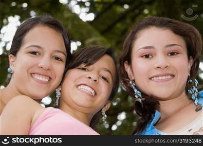 Portrait of a teenage girl smiling with two young women