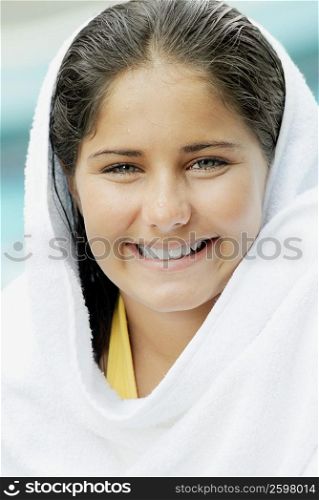 Portrait of a teenage girl wrapped in a towel and smiling