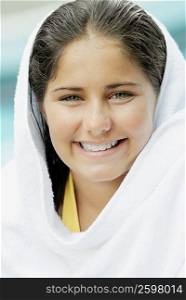 Portrait of a teenage girl wrapped in a towel and smiling