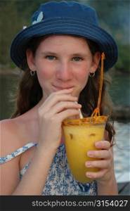 Portrait of a teenaged girl sipping a pineapple drink, Moorea, Tahiti, French Polynesia, South Pacific