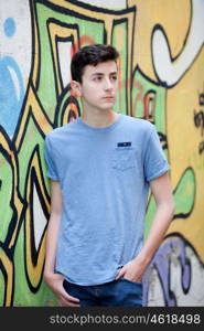 Portrait of a teenager rebellious man on a wall with graffiti background