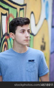 Portrait of a teenager rebellious man on a wall with graffiti background