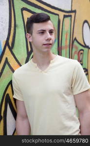 Portrait of a teenager rebellious man on a wall with graffiti background