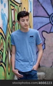 Portrait of a teenager rebellious man on a wall with graffiti background
