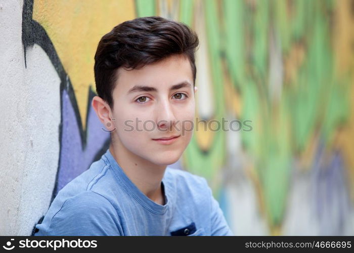 Portrait of a teenager rebellious man on a wall with graffiti background