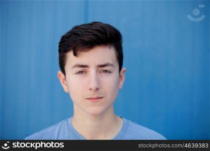 Portrait of a teenager rebellious man with a blue background