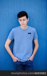 Portrait of a teenager rebellious man with a blue background