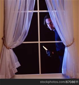 Portrait of a thief peeking through a window