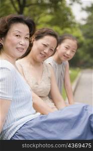 Portrait of a three generation family sitting and smiling in a garden