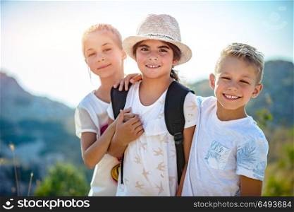 Portrait of a three happy friends outdoors, siblings with pleasure traveling together, having fun in summer camp, best friends forever. Three happy friends
