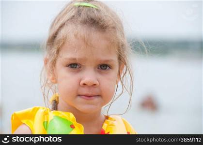Portrait of a three-year girl on the beach in the lifejacket. Portrait of a three-year girl on the beach