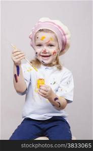 Portrait of a three-year old girl playing in the artist. Girl mud paints