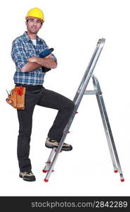 Portrait of a tradesman with his foot propped on a stepladder