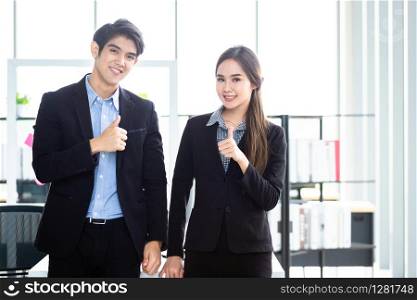Portrait of a two businessman and businesswoman partners discussing positive adult business showing thumbs up and ideas at meeting in office background