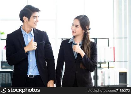 Portrait of a two businessman and businesswoman partners discussing positive adult business showing thumbs up and ideas at meeting in office background