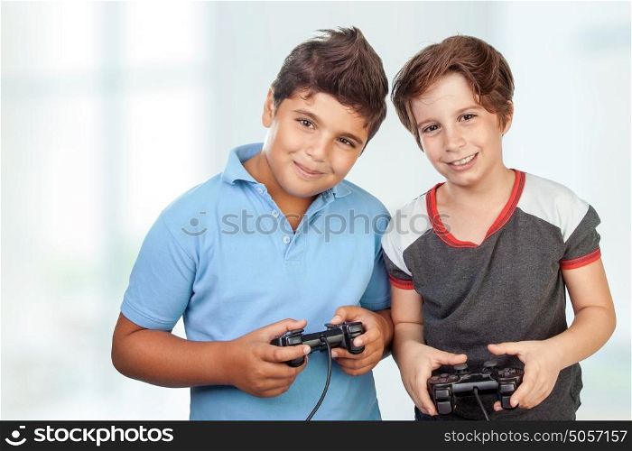 Portrait of a two cute happy boys playing video games at home, best friends enjoying competition on playstation, with pleasure having fun together