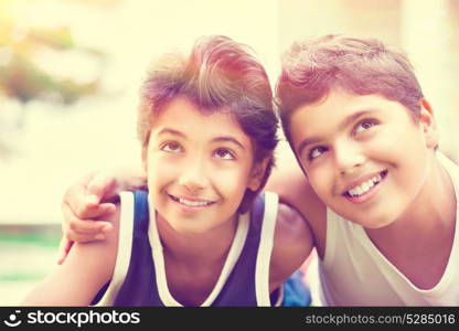 Portrait of a two happy boys lying down on the field in sunny day, best friends spending time together, summer holidays in the camp