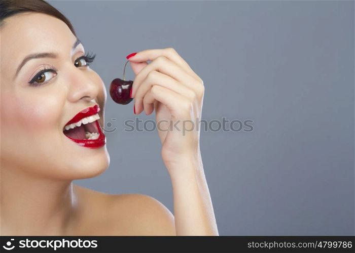 Portrait of a woman about to eat a cherry