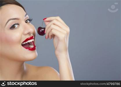 Portrait of a woman about to eat a cherry