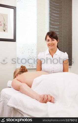 Portrait of a woman acupuncturist with patient ready for therapy