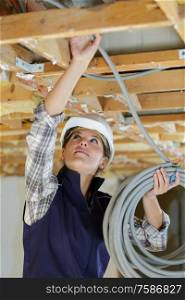 portrait of a woman builder holding cables