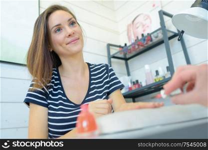 portrait of a woman during nail polish application