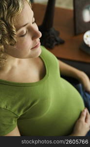 Portrait of a woman five months pregnant breathing with eyes closed