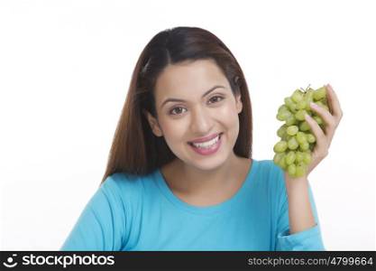 Portrait of a woman holding grapes