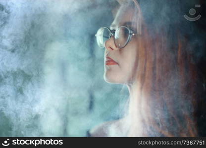 portrait of a woman in a smoke, eyes in glasses / business concept, beautiful woman, sexy business girl. Stress, smoking, relaxed.