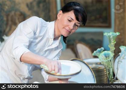 portrait of a woman is cleaning dishes
