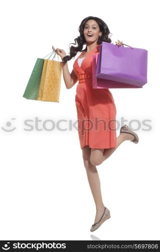 Portrait of a woman jumping with shopping bags