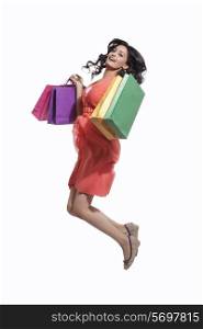 Portrait of a woman jumping with shopping bags