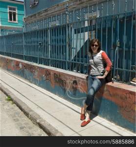 Portrait of a woman leaning against a fence, Valparaiso, Chile