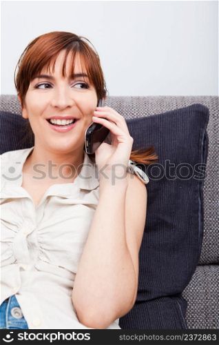 Portrait of a woman on a sofa, talking on phone
