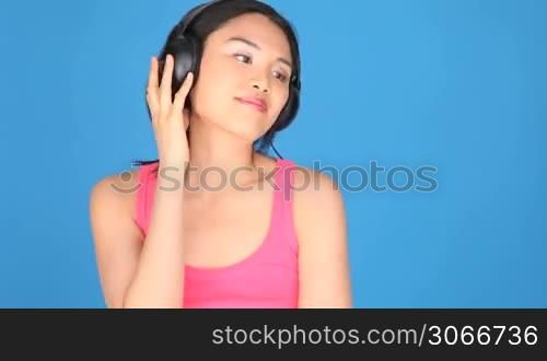 Portrait of a woman singing and listening to music through headphones