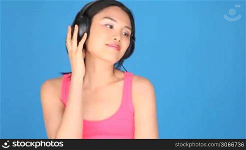 Portrait of a woman singing and listening to music through headphones