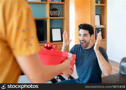 Portrait of a woman surprising her boyfriend with a present. Celebration and valentine’s day concept.