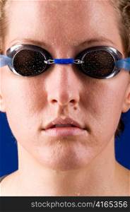 portrait of a woman swimmer looking at camera on blue background