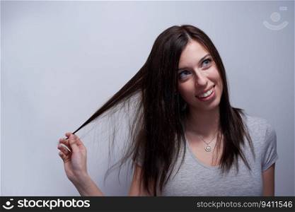 Portrait of a woman touching her hair like if it&rsquo;s damaged
