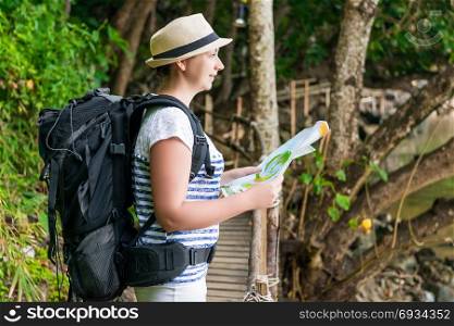 portrait of a woman with a map and a backpack on a trip to Asia