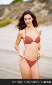 Portrait of a woman with beautiful body on a tropical beach wearing red bikini. Portrait of a woman with beautiful body on a tropical beach