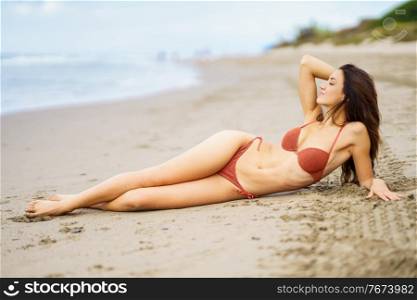 Portrait of a woman with beautiful body on a tropical beach wearing red bikini. Portrait of a woman with beautiful body on a tropical beach