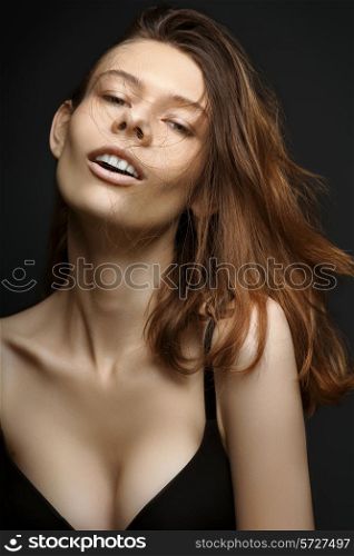 Portrait of a woman with disheveled hair on black background