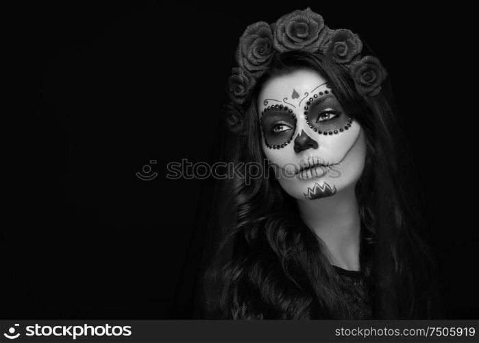 Portrait of a woman with sugar skull makeup over black background. Halloween costume and make-up. Black and white Portrait of Calavera Catrina