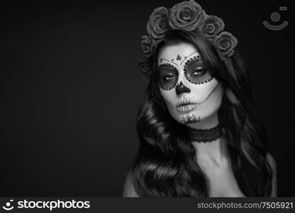 Portrait of a woman with sugar skull makeup over black background. Halloween costume and make-up. Black and white Portrait of Calavera Catrina